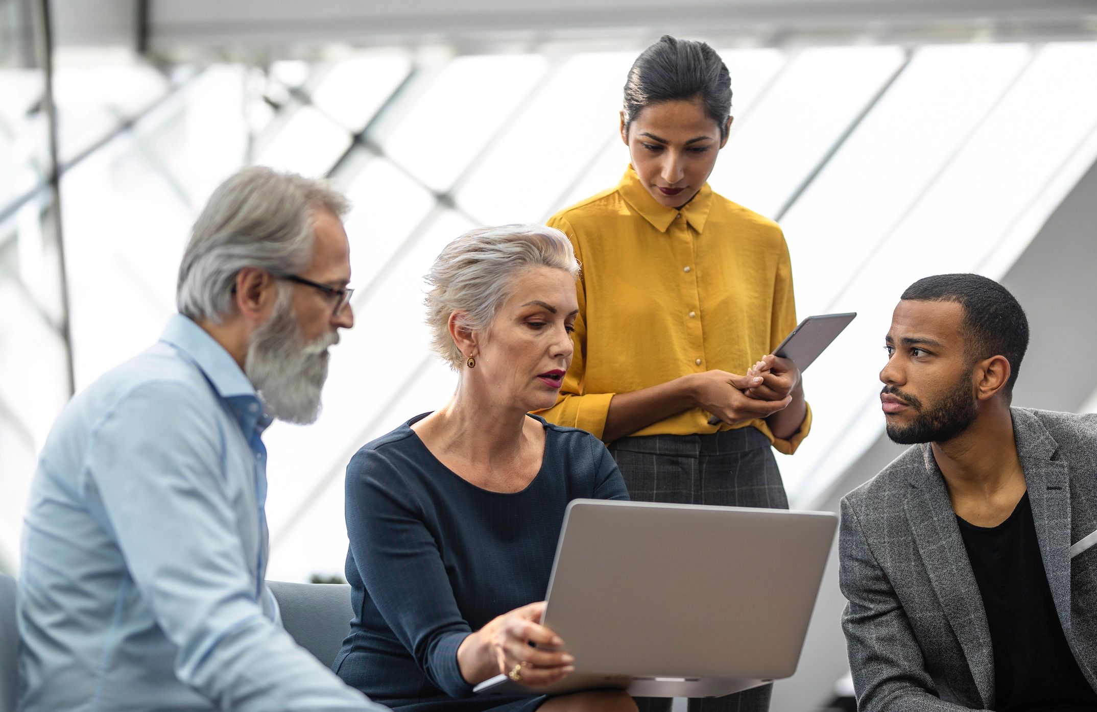 IT team reviewing a plan on a tablet in a modern office