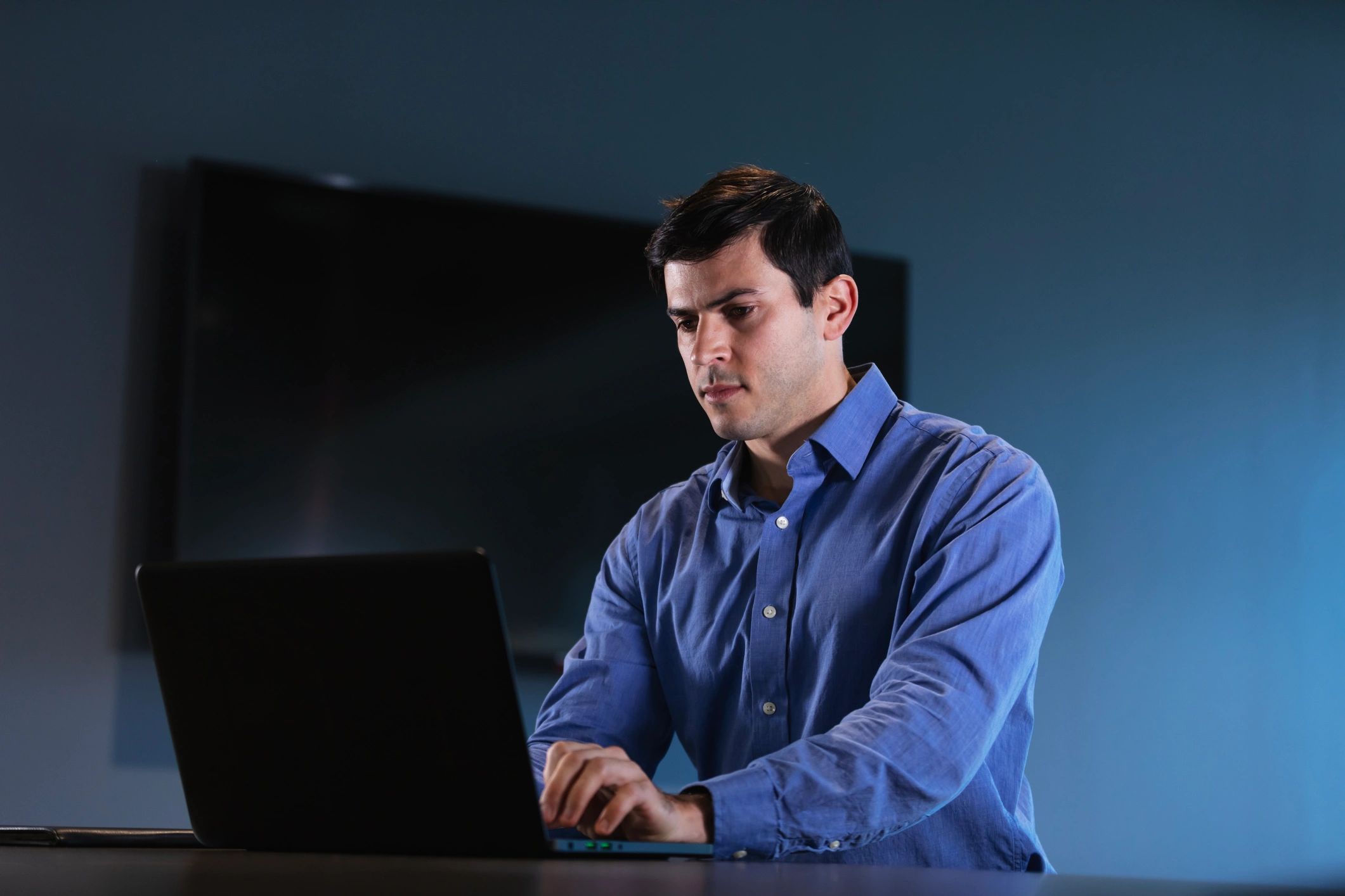 IT professional working on a laptop in an office